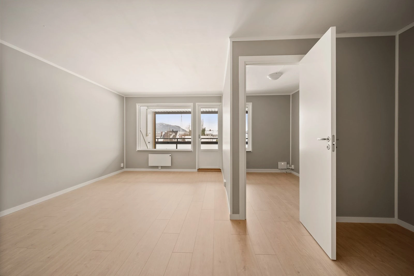 Lyse flater og store vindusflater gir en luftig romfølelse.