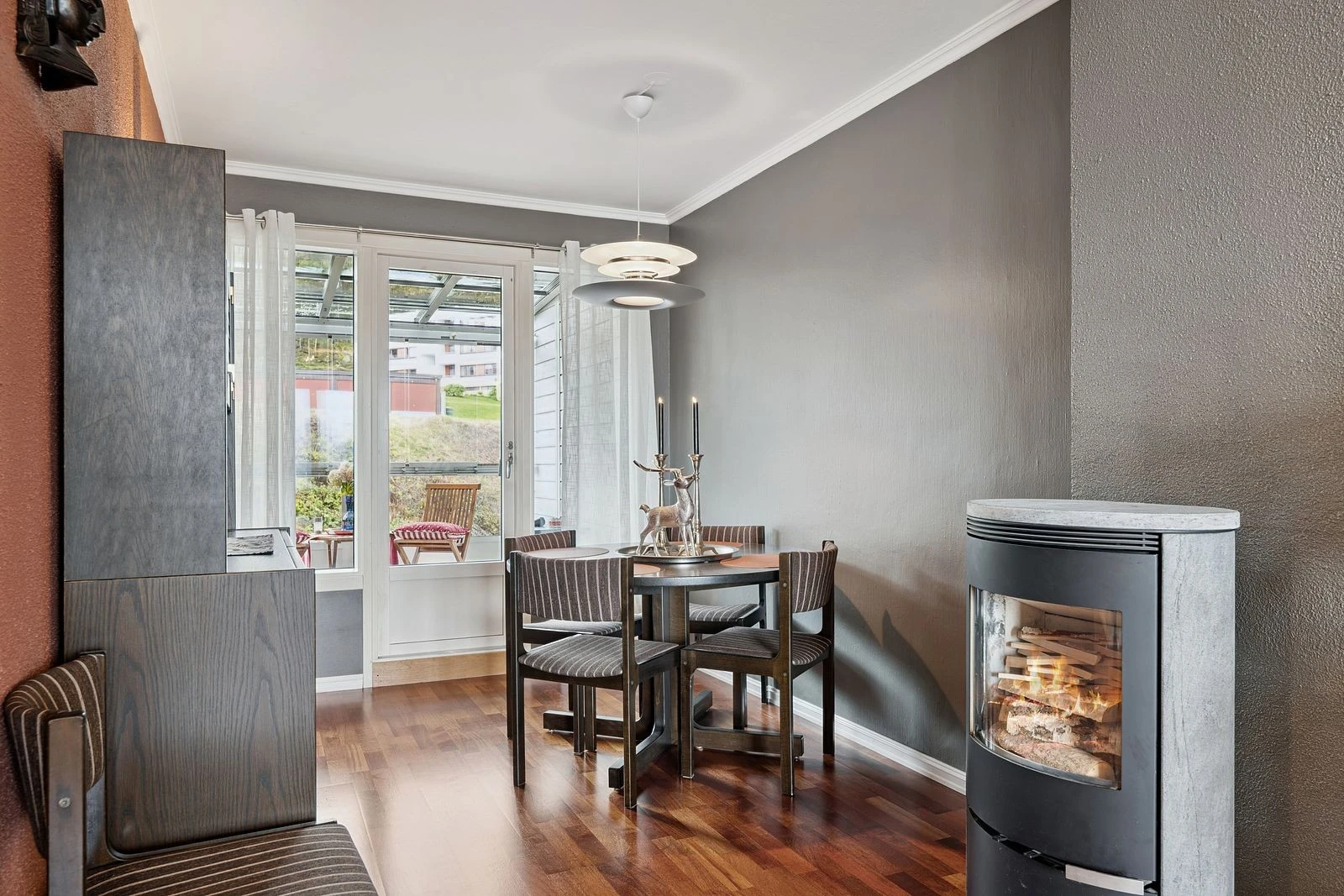 Kombinasjonen av moderne stil og vedovn gir stuen et lunt og innbydende preg.