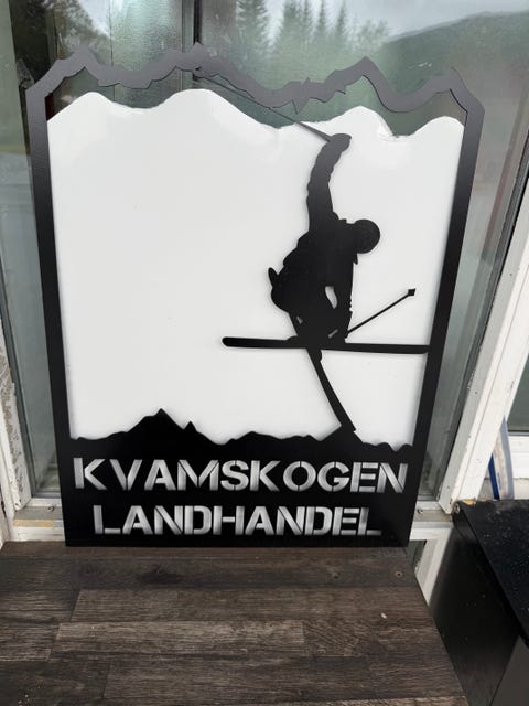 Skilt med tekst "Kvamsskogen Landhandel"