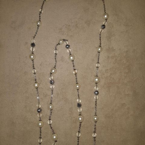 Veldig langt halskjede med dekorative perler og roser i metall.