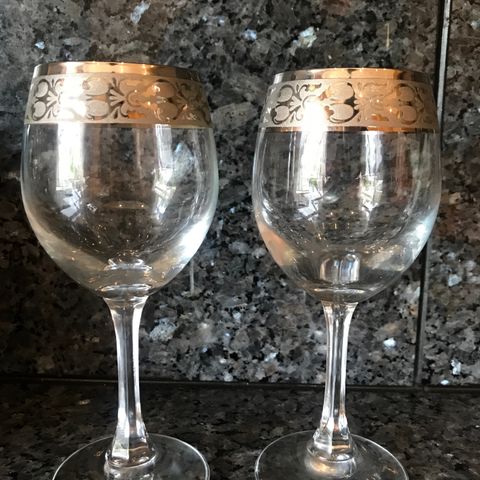 Et par unike vinglass med sølv mønster på toppen
