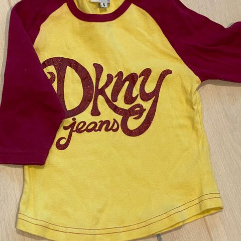 Litt innsvinget topp med 3/4-erm fra DKNY, str 6 år