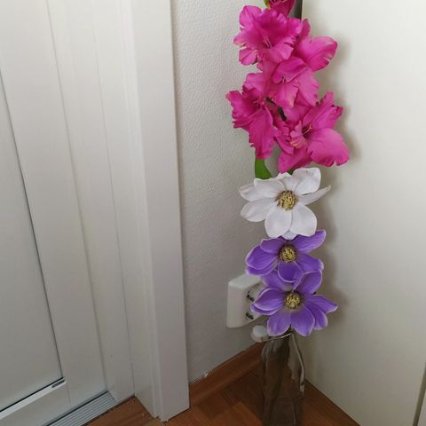 Kunstig blomsterdekor og vase selges samlet.
