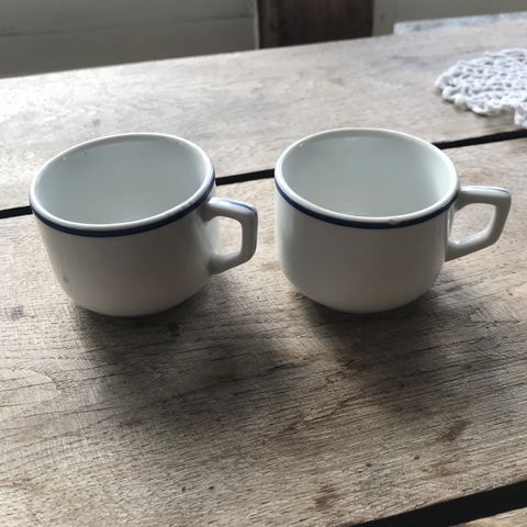 2 små kopper . Hvite med blå kant 