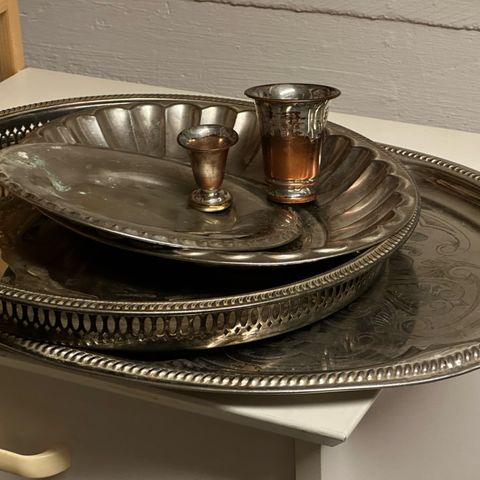 Sølvfargede fat og to sølvfargede kopper, selges samlet til høystbydende.