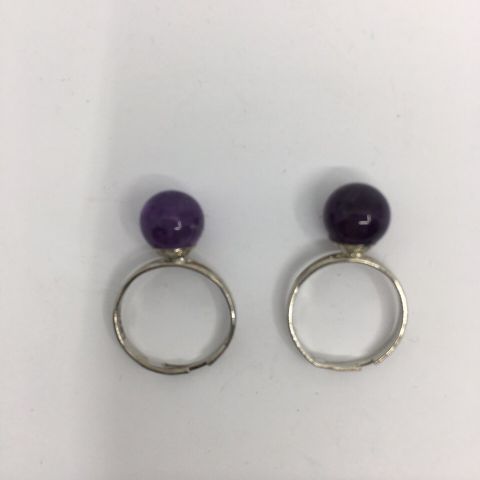 To sølvfargede, regulerbare ringer med lilla sten/kule. Bijouteri