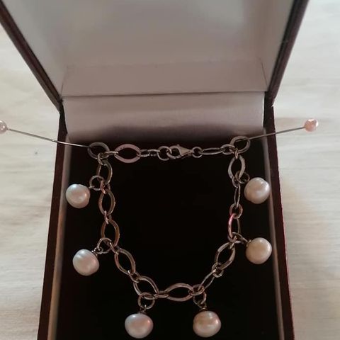 Selger  et pen sølv armbånd  med ekte perler som henger ned.