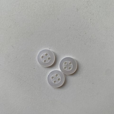 3 stk. små knapper i hvit litt transparent plast. 