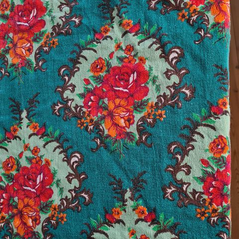 Retro flott tekstil, røde og orange blomster, grønn bunn