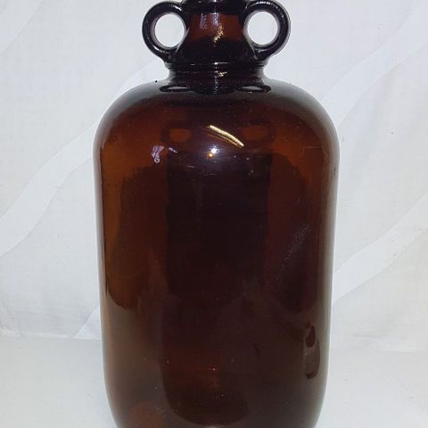 Stor brun flaske med dobbel hank og etikett