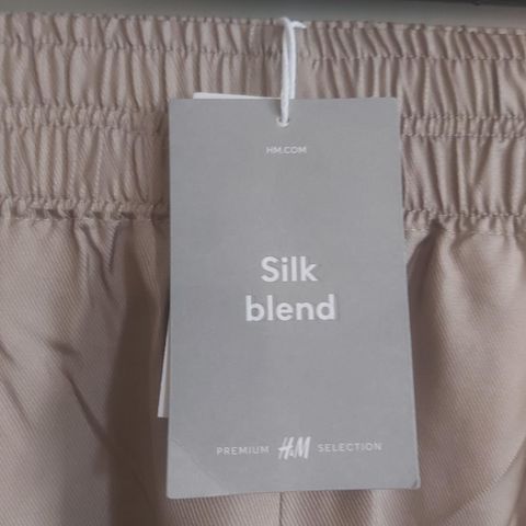 55% SILKE sølv-beige bukse. 2 dype lommer. Strikk i livet. H&M.