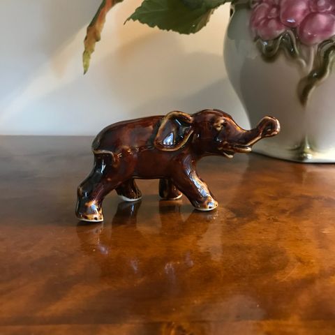 Liten, brun elefant i porselen