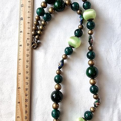 Grønt halskjede med skinnende perler