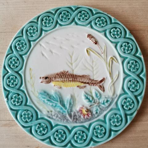 Antikk majolika platte med håndmalt motiv av fisk, selges.