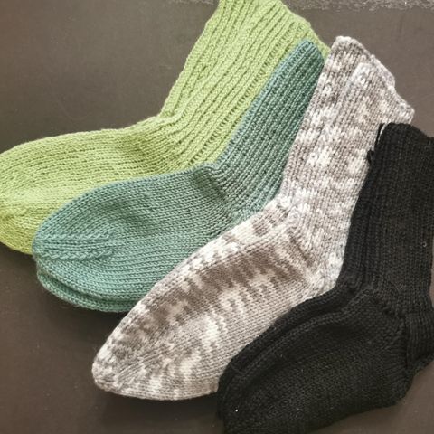 Hjemmestrikka sokker i forskjellige størrelser og farger