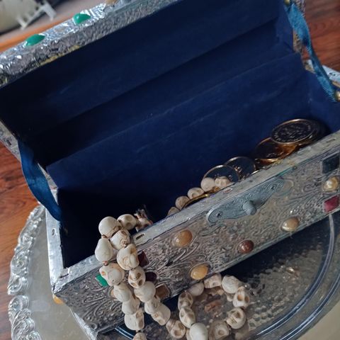 Kiste med gullpenger og smykke av dødningehoder kr 500