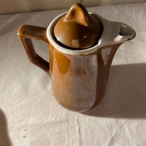 Søt brun liten kanne i porselen (te,kaffe,saus)