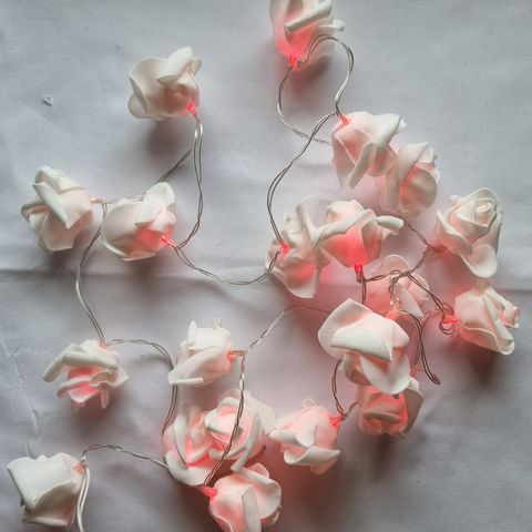 Lang rekke blomster av papir/stoffaktig mykt materiale som lyser og blinker rosa