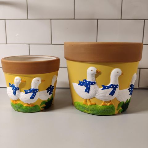 2 blomsterpotter med hyggelige påskemotiver selges samlet.