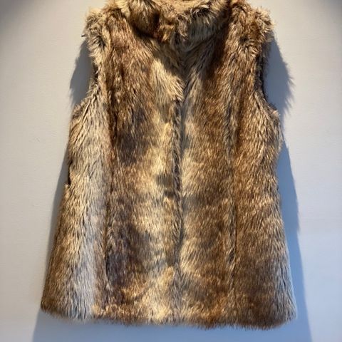 Denne flotte pelsvesten passer over en kjole eller en skjorte/genser