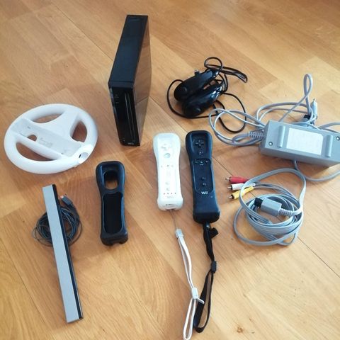 Nintendo wii med 2 konsoller, 2 joystick, 1 sensor, 1 ratt og alt av ledninger.