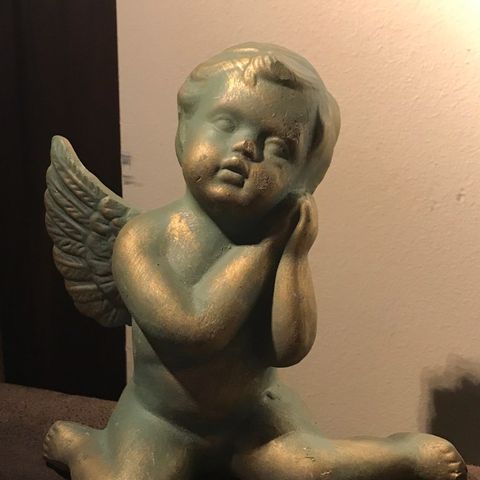 En nydelig sittende engel i keramikk.