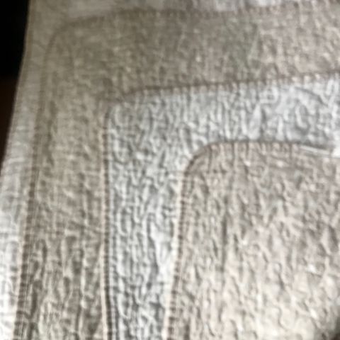 Pent brukt vattert sengeteppe i beige/ off white. m /tekst. 140x200 cm