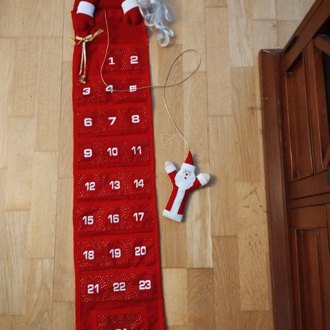 Adventskalender i stoff med julenisse og lommer