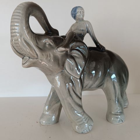 Elefant i porselen med gutt på ryggen
