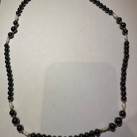 Halskjede med sorte og hvite "perler"