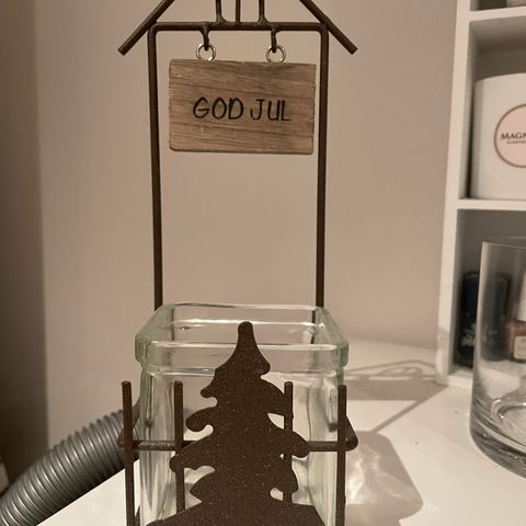 Telysholder glass og metall med God jul skilt over og juletre foran.H24 cm