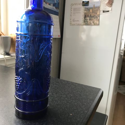 Blå flaske med fine ornamrnter.