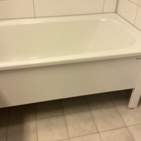 Hvitt emaljert badekar fra Svedberg med dusjvegg, dusjstativ og blandebatteri