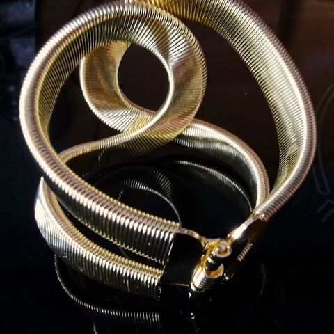 Nytt elegant armbånd laget av gyllent metall.
