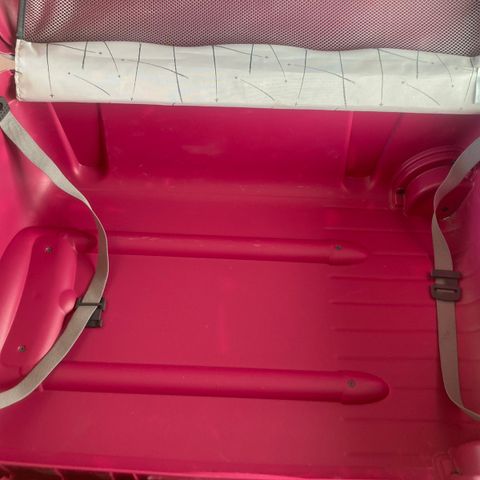 Pent brukt rosa koffert.