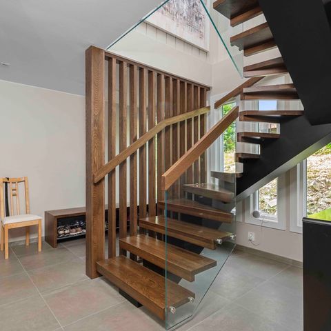 Moderne trapp med glassrekkverk og spilevegg