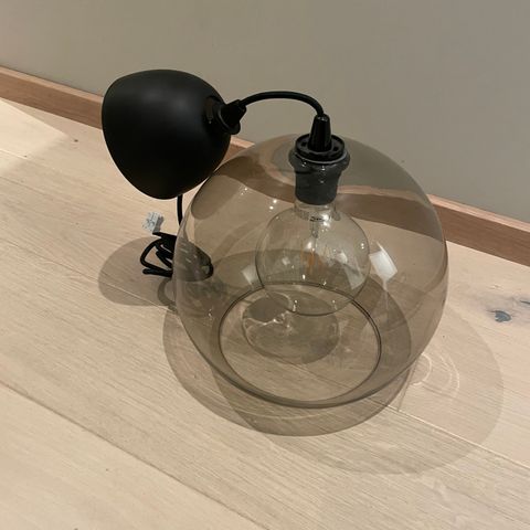 Sort lampe med sotet glass selges