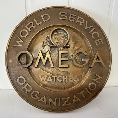 OMEGA World Service logo i bronse