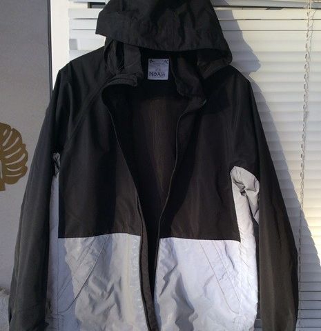 Sort lett vanntett  jakke med refleksdel nederst og avtagbar hette.  STR. 170