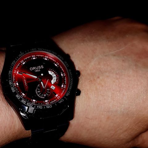 Tøff sort klokke med rød skive til salgs.