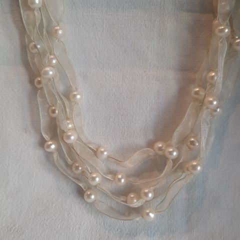 Halskjede/halssmykke: Rader med perler tredd på silkebånd