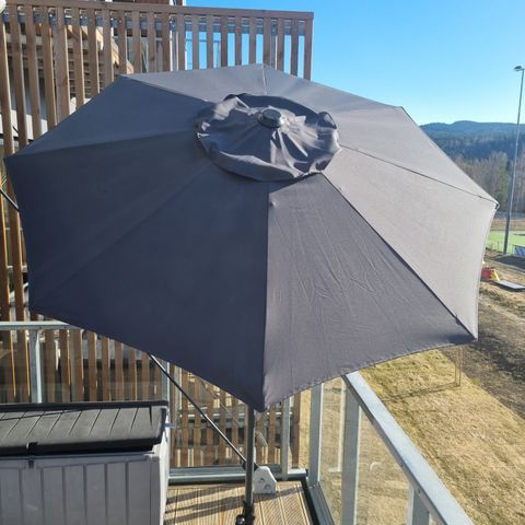 Lite brukt parasoll med betongfot