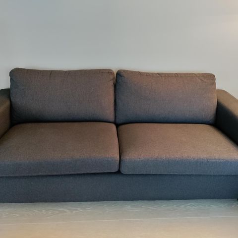 Selger en gråsvart toseter sofa fra Skeidar