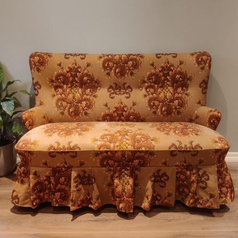 Søt liten vintage sofa med blomstrete trekk og teak bein