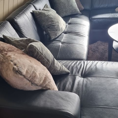 Sort sofa med sjeselong i imitert skinn
