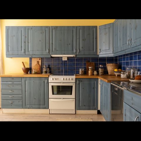 Kjøkken med heltre benkeplate, Miele oppvaskmaskin, komfyr og kjøleskap