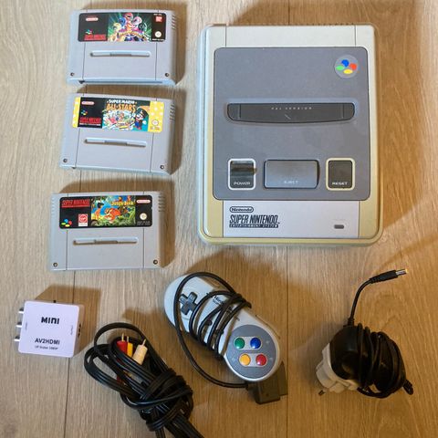 Super Nintendo med spill, kabler og adapter