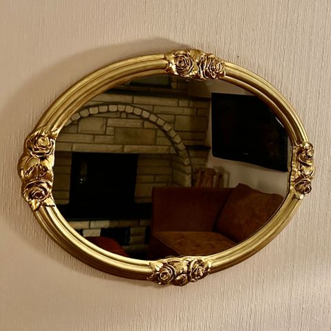Vintage ovalt gullfarget speil med "rosett" dekor selges.