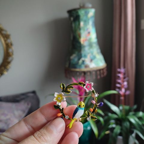 Gullfarget brosje brystnål med en fugl og blomster