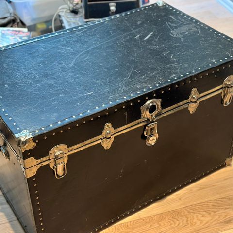 Eldre rustikk kiste i svart med ståldetaljer